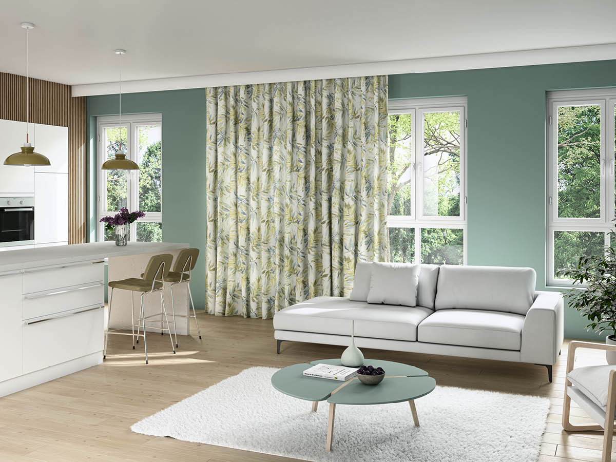 Ein in grün weiß gehaltenes Wohnzimmer mit offener Küche mit der Gardine Nevis.